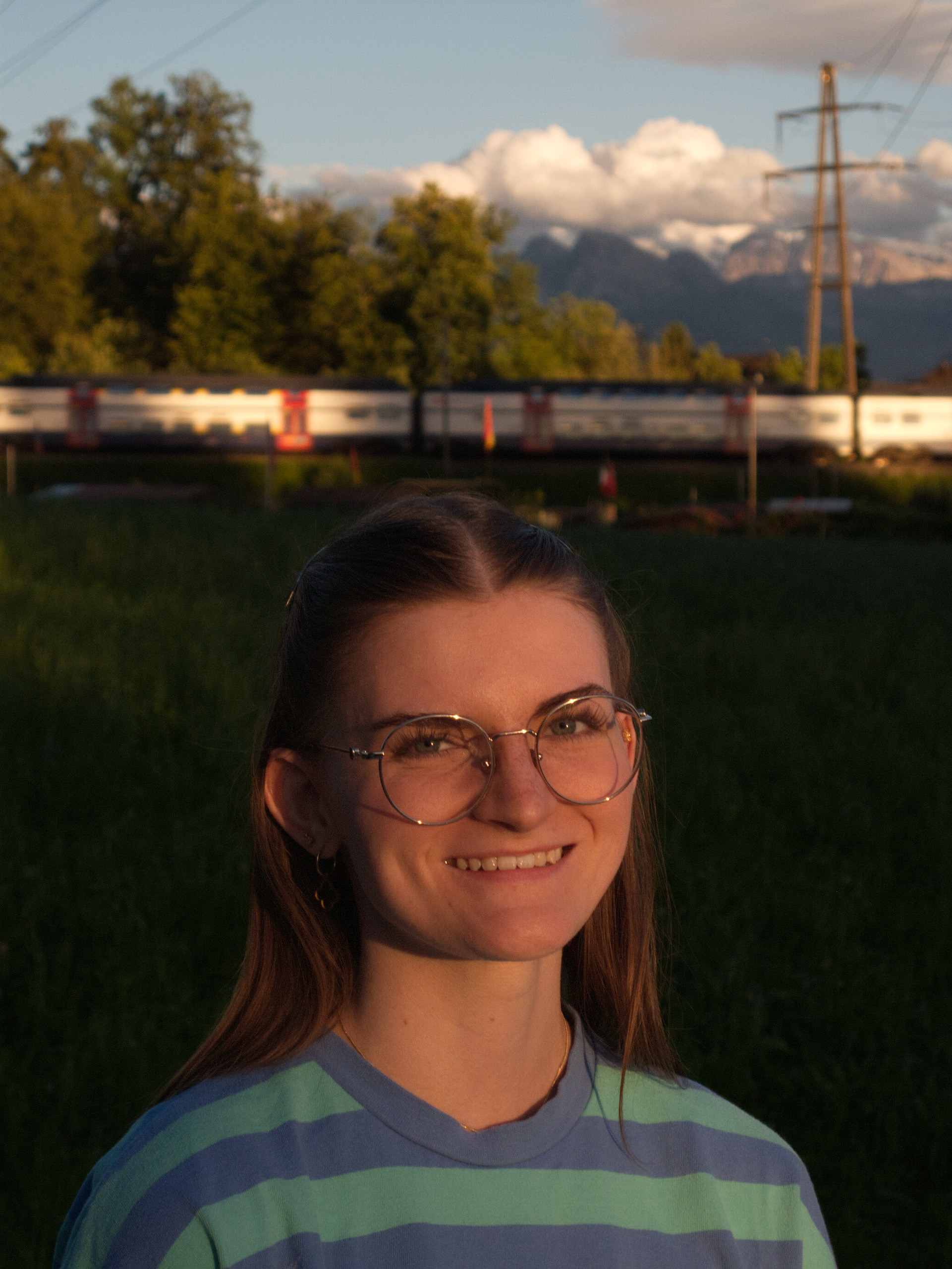 Porträt von Lisa Karschunke vor einer Schweizer Abendlandschaft